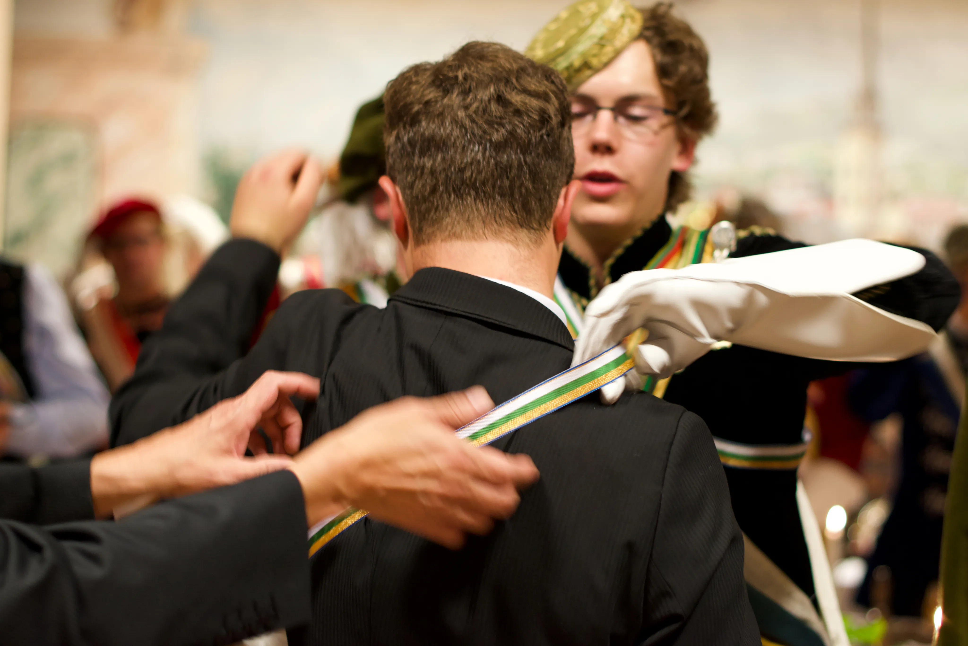 Freunde in einem holzvertäfelten Studierzimmer, die lachend Geschichten austauschen.